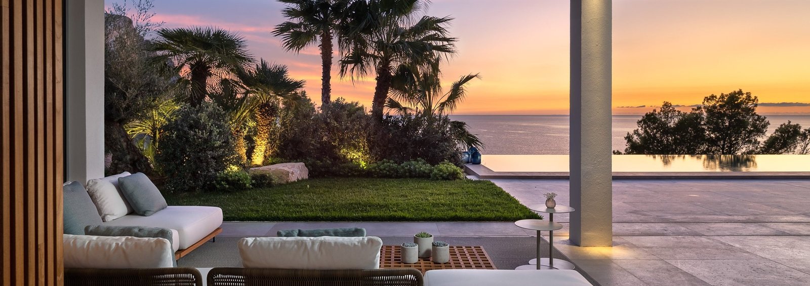 Garten mit Palmen und Beleuchtung bei Sonnenuntergang in einer Villa auf Mallorca