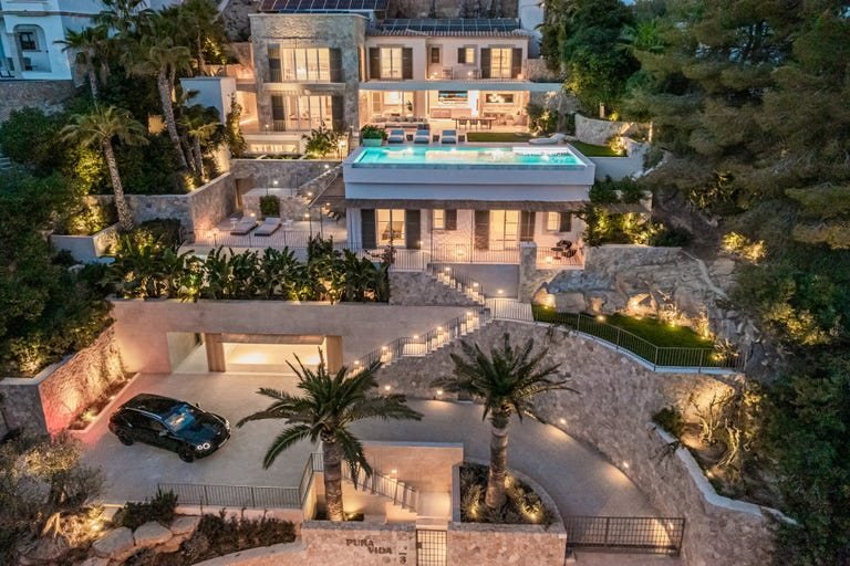 Luxusvilla mit beleuchtetem Garten und Pool in der Abenddämmerung, Mallorca